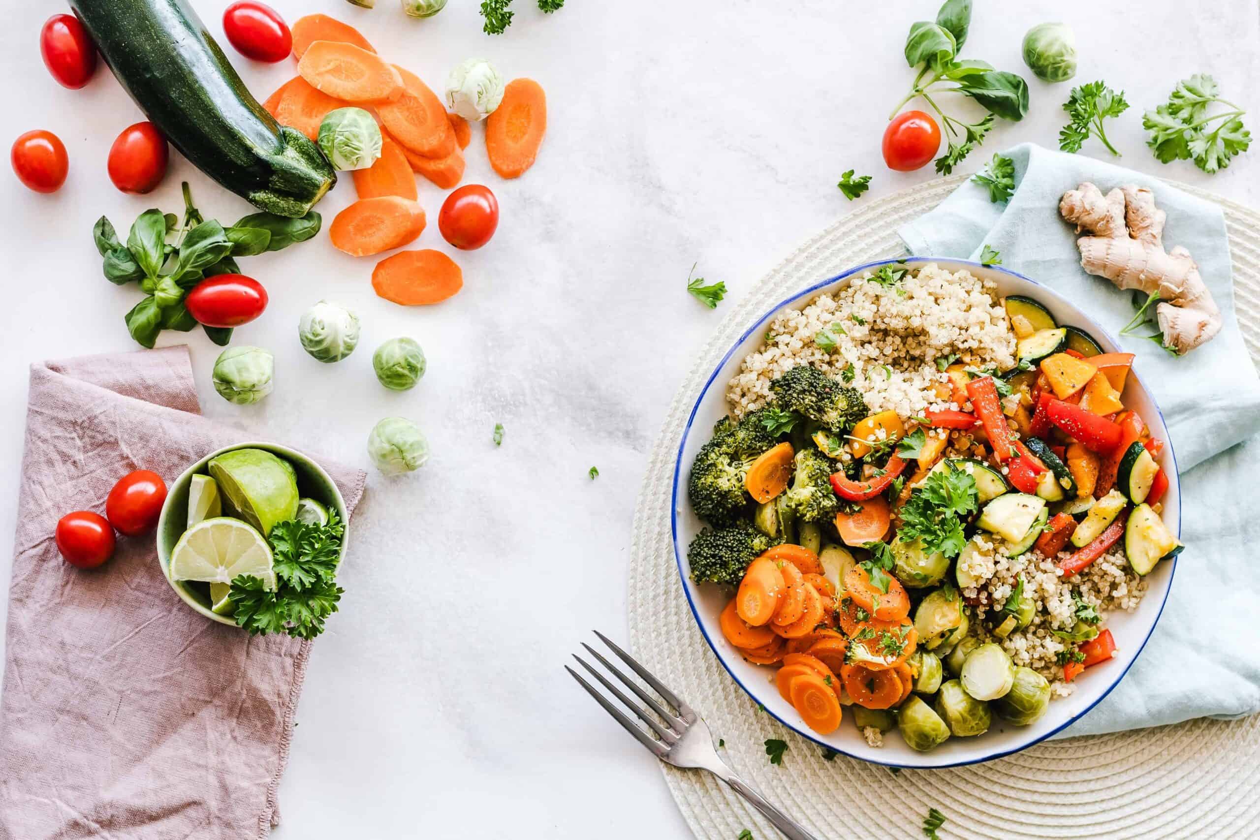 Quinoa and vegetables meal prepped in a bowl with a fork