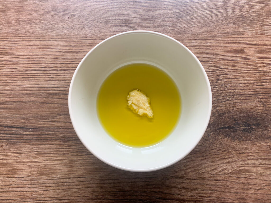 Adding minced garlic to extra virgin olive oil