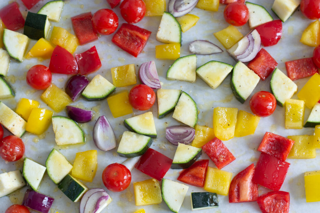 Mediterranean vegetables on a baking tray just before roasting