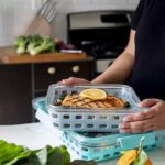 Woman putting her chicken meal prep in storage containers