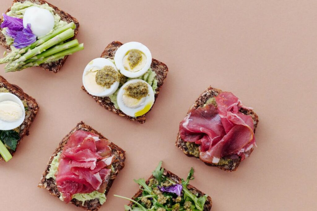 Sandwiches topped with various toppings laid out in a table
