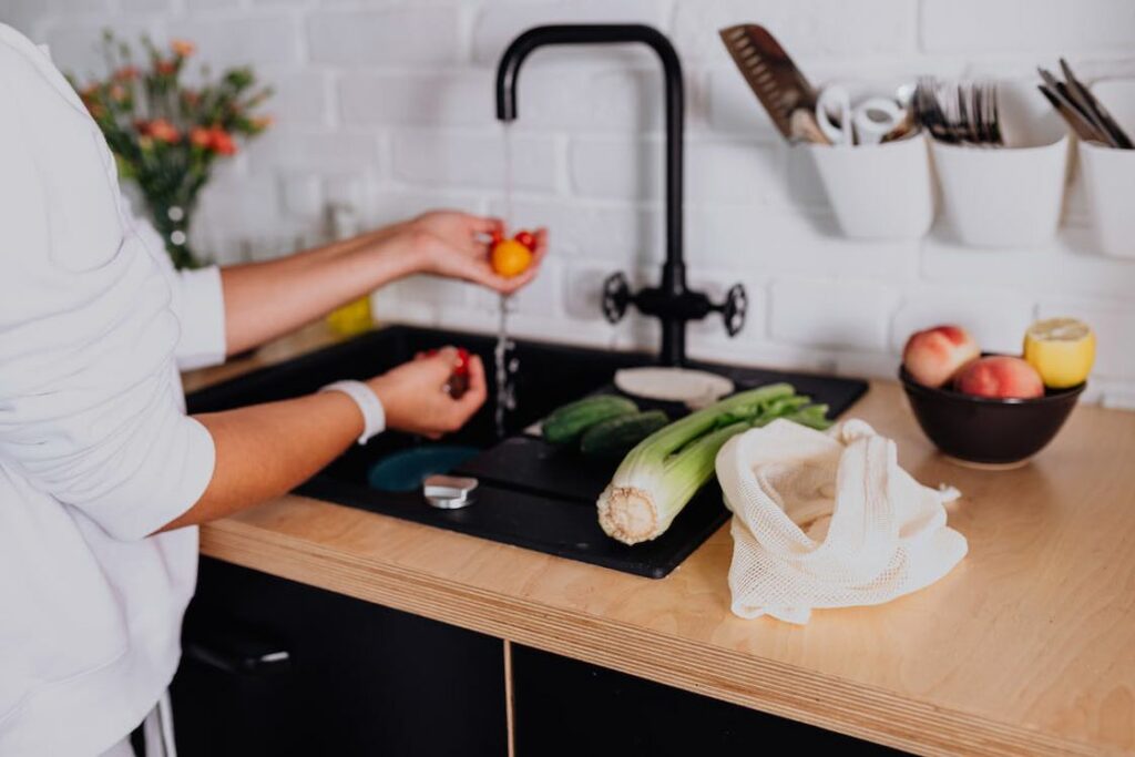 Person cleaning vegetables in the sink