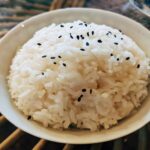 White rice sprinkled with black sesame seeds on a bowl
