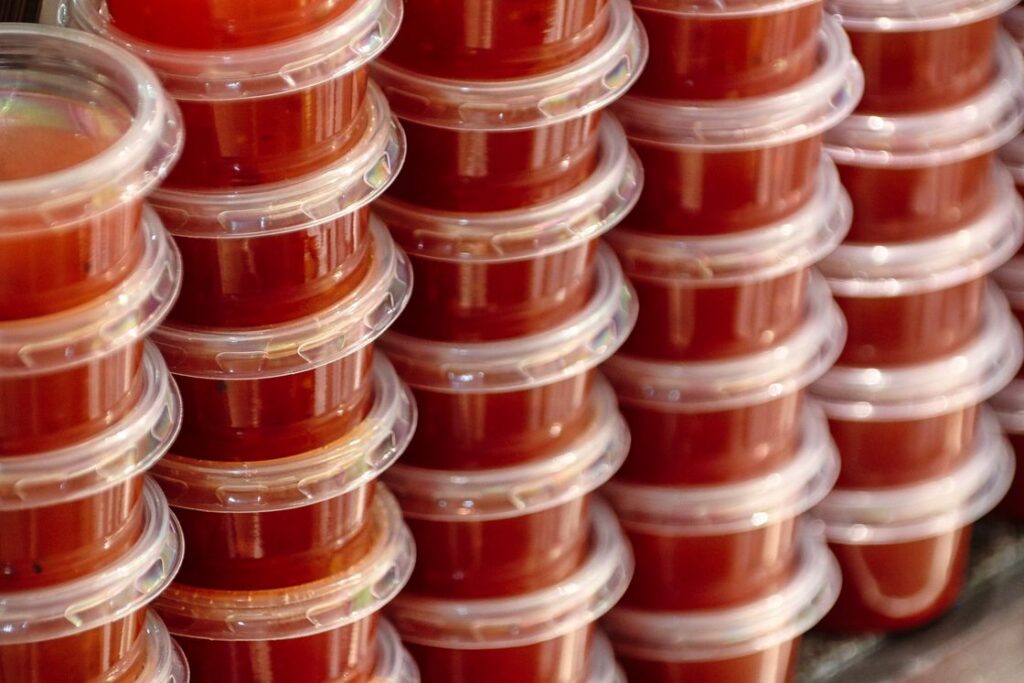 Pasta sauce stored in plastic containers and stacked on top of each other