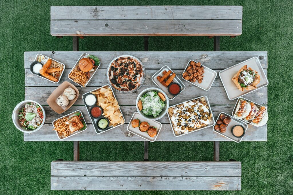 An assorted variant of food on top of a brown wooden table placed on top of a green floor