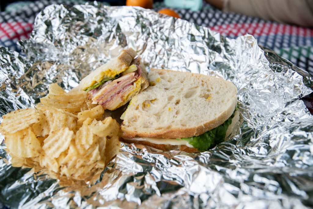 A sandwich bread with chips on an aluminum foil