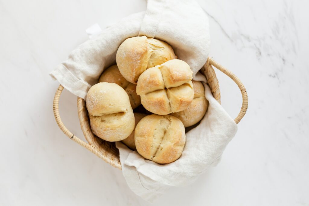 White breads in a wicker basket with a white Boule bag