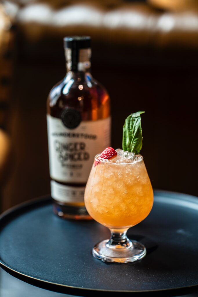 A ginger spiced bottle with a glass of cocktail