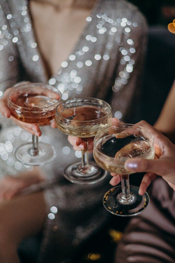 Three persons holding three cocktail glasses