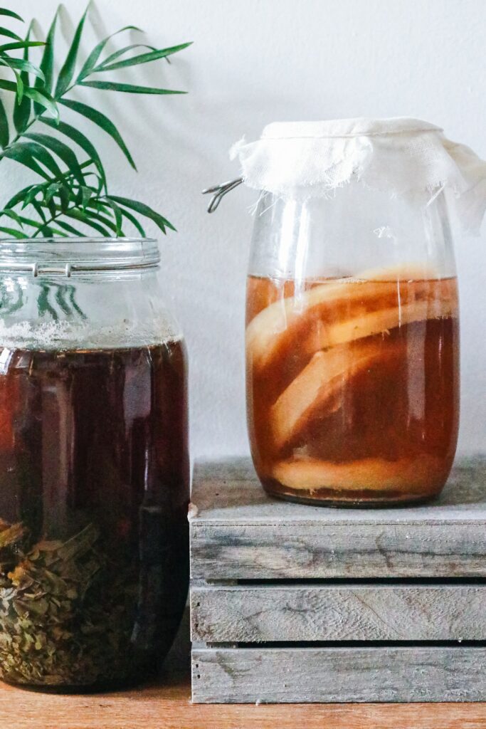 A jar of kombucha tea with a jar of herbal beverage
