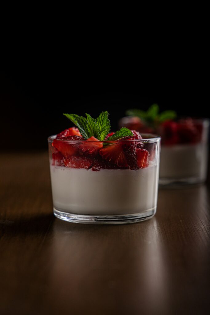 A glass of yogurt with strawberries on top