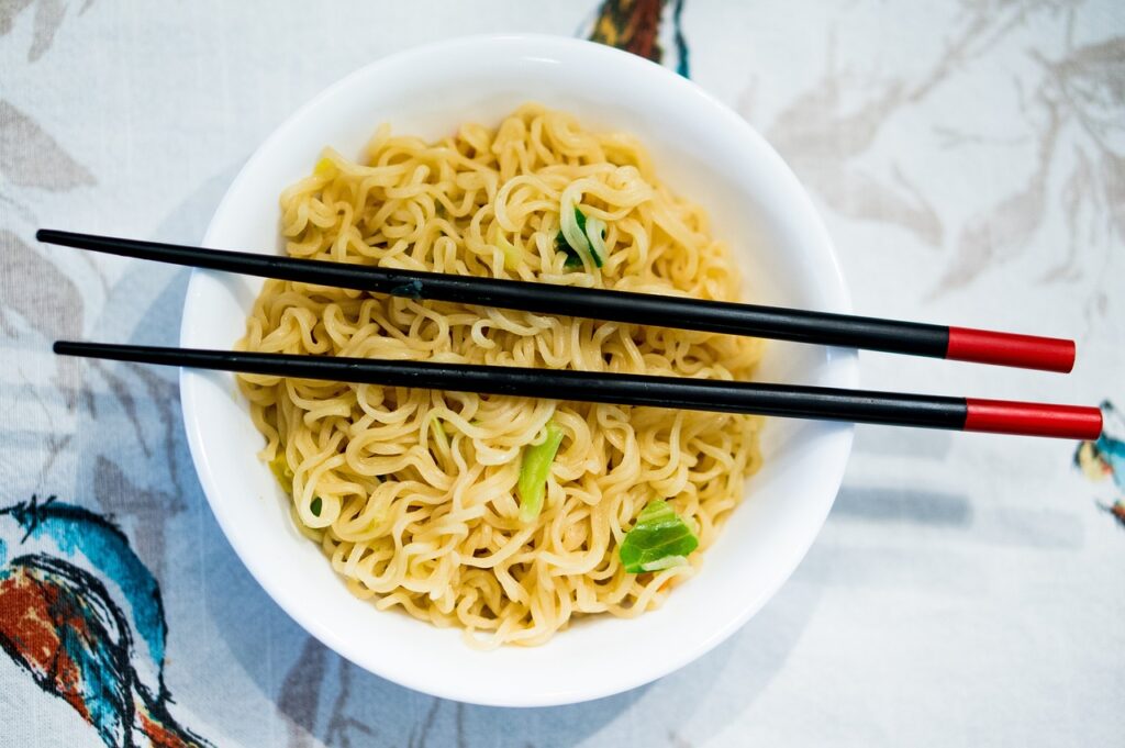 Japanese noodle on a bowl with black chopsticks on top of it