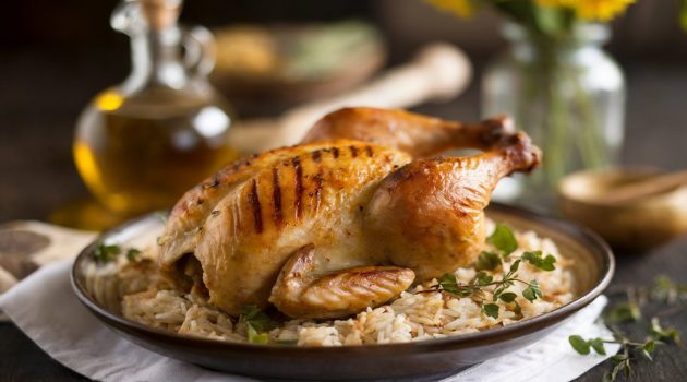 A roasted chicken with herbs on seasoned rice