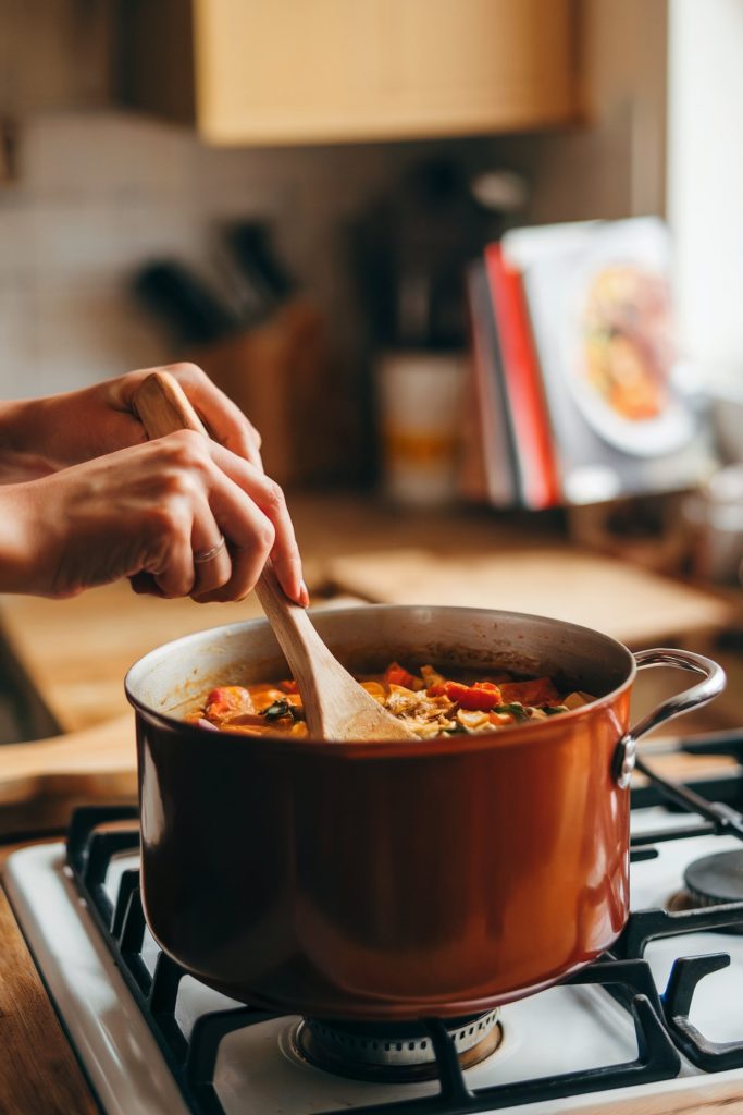 A woman stirring the meal on a pot