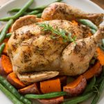 A whole baked chicken with beans and sweet potatoes