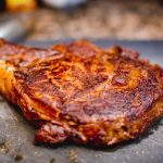 Perfectly seared rib-eye steak resting on a cutting board
