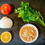 Ingredients for tabbouleh: fresh parsley, onion, tomato, bulgur, and lemon