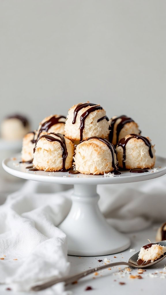 Coconut macaroons drizzled with chocolate on a white cake stand.