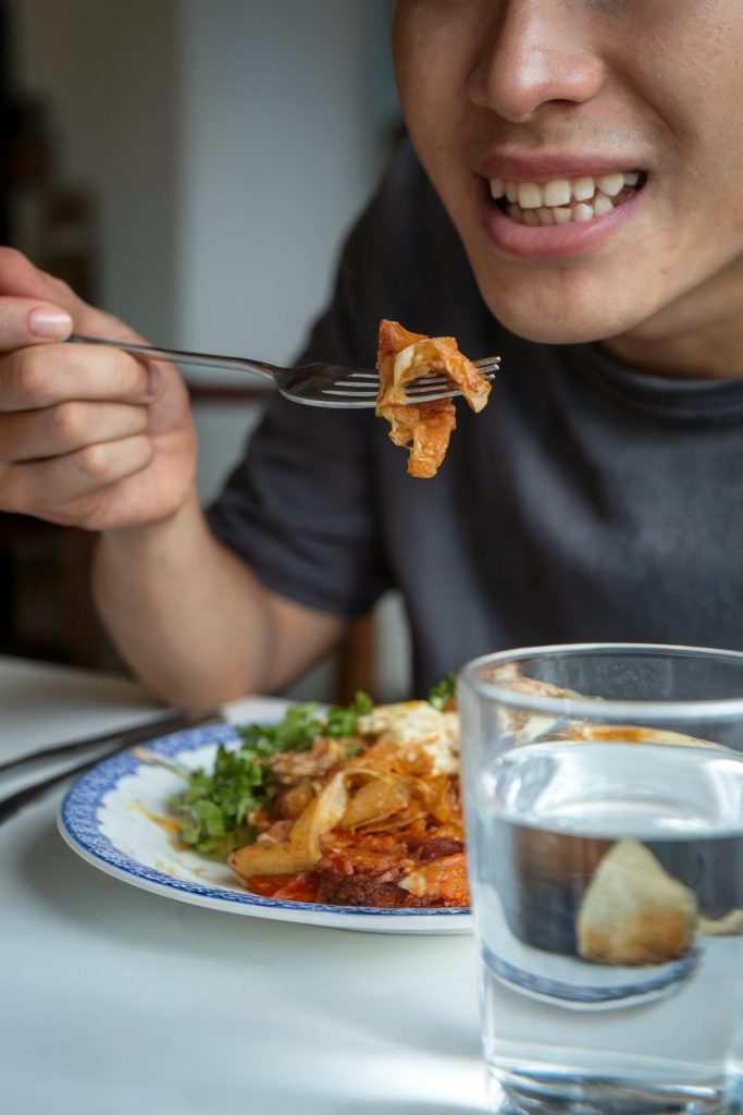 A person eating using a fork