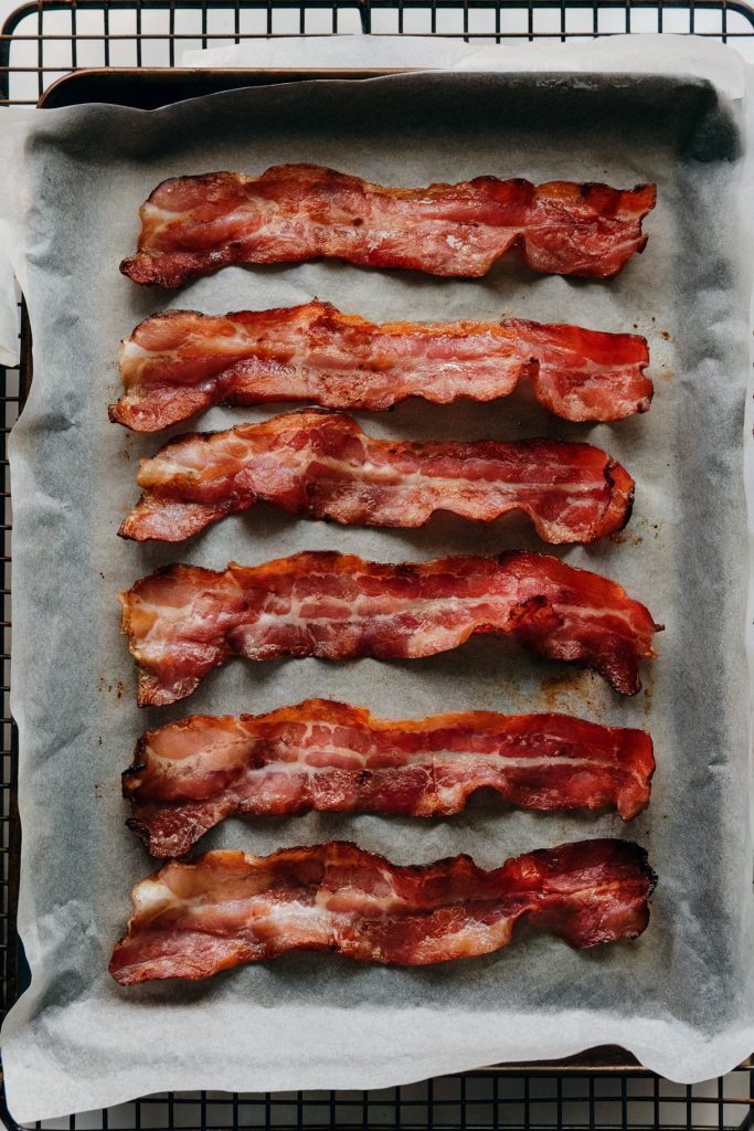 Strips of cooked bacon on a parchment paper