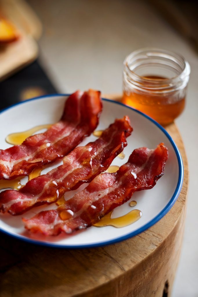 Three pieces of bacon strips with honey drizzle