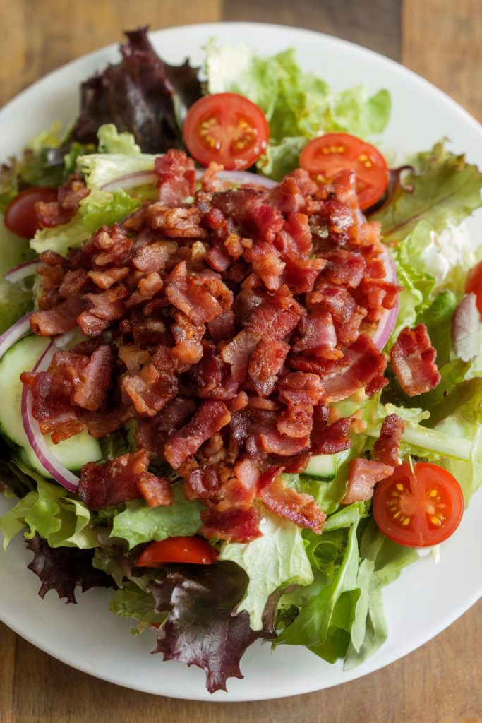 A salad topped with chopped bacon