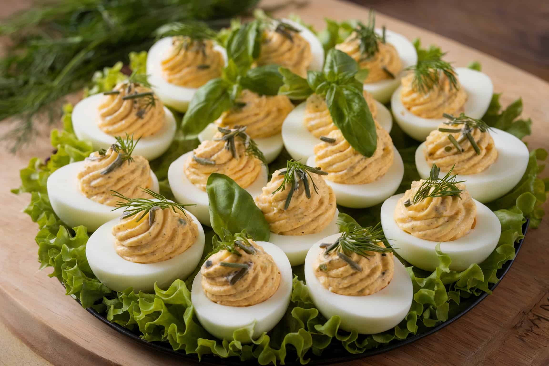 A dozen deviled eggs with lettuce