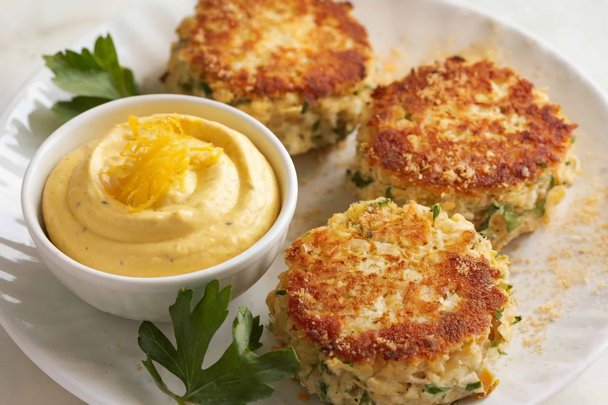 Golden brown crab cakes on a white plate