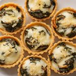 A plate of mini cheese and spinach savory tarts