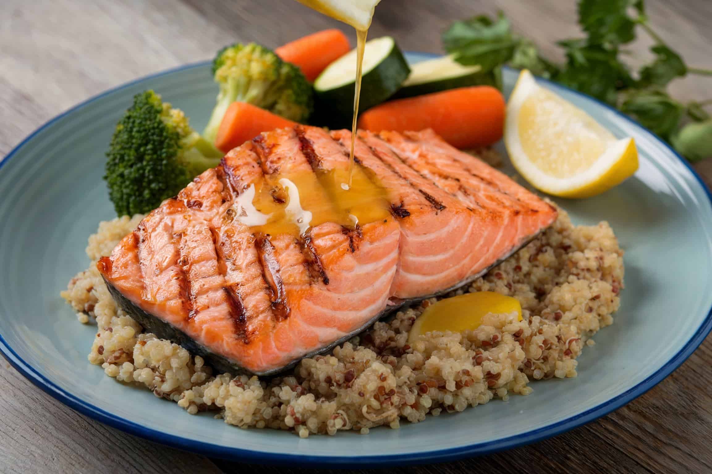A plate of grilled salmon with quinoa and steamed vegetables