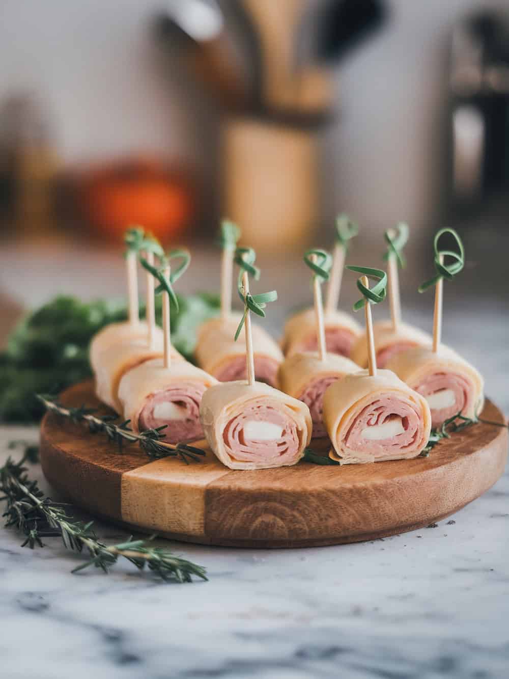 Mini turkey and cheese roll-ups on a wooden board