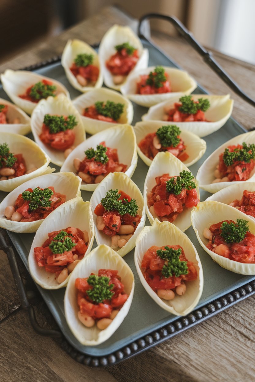 Indoor appetizer tray featuring small endive leaves filled with tomato-white bean mixture, topped with parsley. No text or logos.